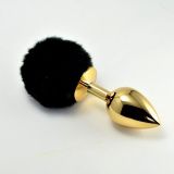 Golden anal toy with a black pompom